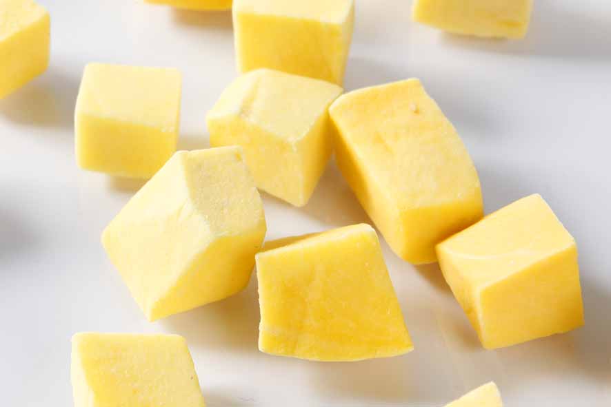 frozen diced mango on white background